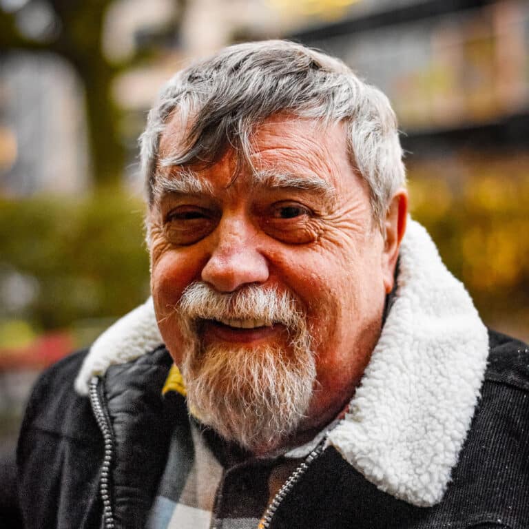 Lächelnder älterer Mann mit grauem Haar und Bart